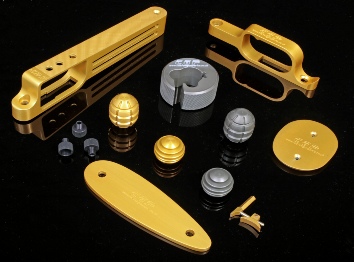 Studio shot of CNC machined parts for air rifles and firearms, trigger guards, triggers and bolt knobs